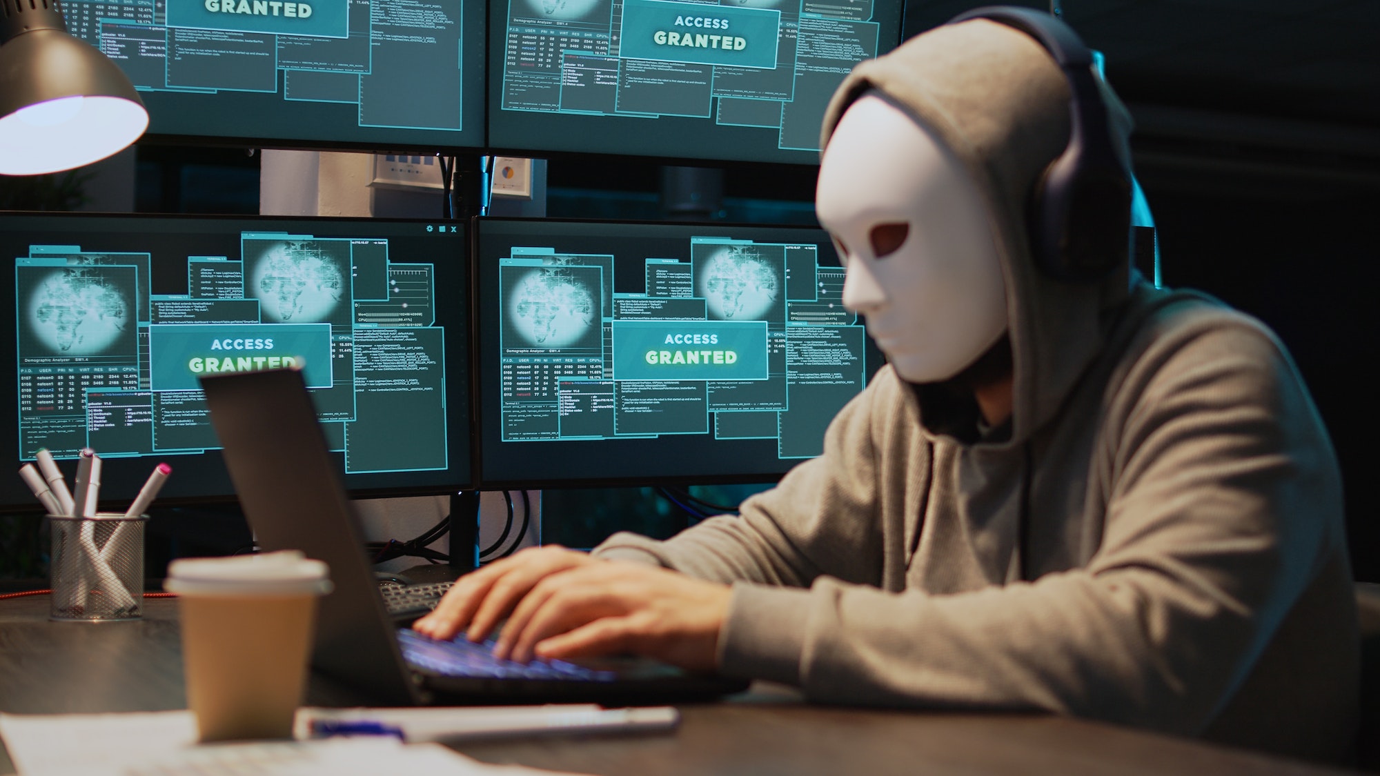 Masked cyber thief hacking computer network at night